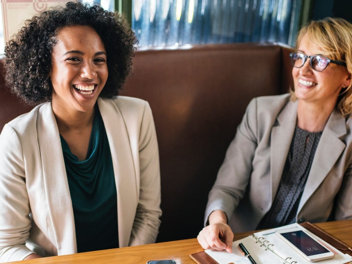 women laughing at business meeting