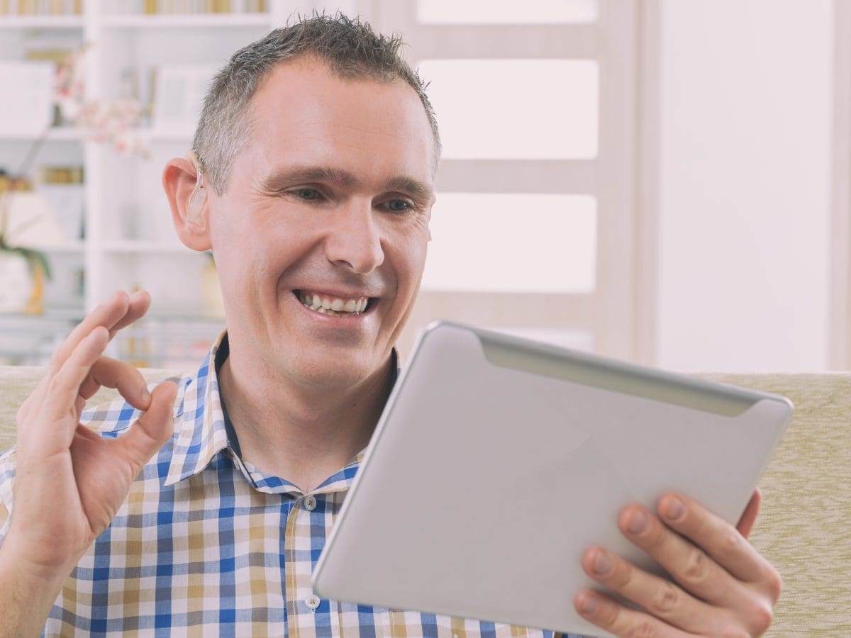 man smiling at tablet